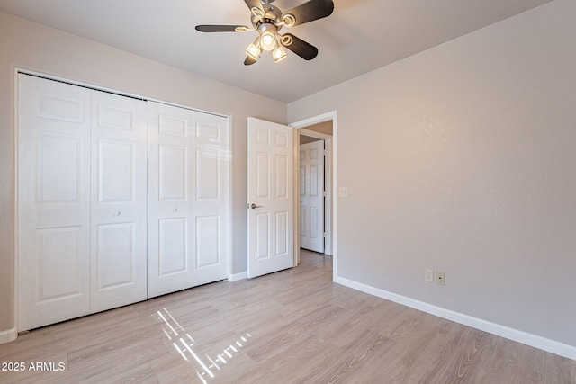 unfurnished bedroom featuring ceiling fan, light hardwood / wood-style floors, and a closet