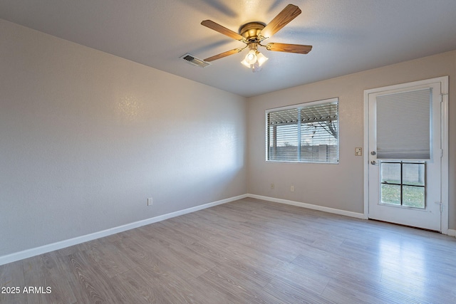 unfurnished room with ceiling fan, plenty of natural light, and light wood-type flooring