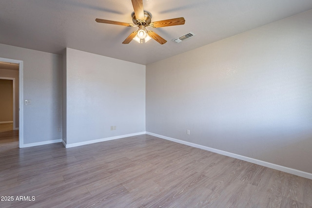 empty room featuring ceiling fan and light hardwood / wood-style floors