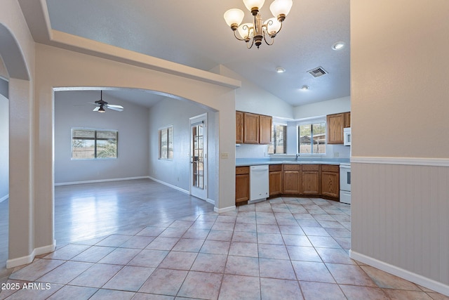 kitchen featuring light tile patterned floors, white appliances, vaulted ceiling, and ceiling fan with notable chandelier