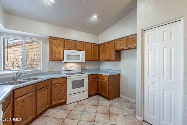 kitchen featuring lofted ceiling, sink, white appliances, and light tile patterned floors