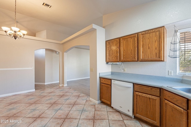 kitchen featuring decorative light fixtures, sink, light tile patterned floors, white dishwasher, and an inviting chandelier