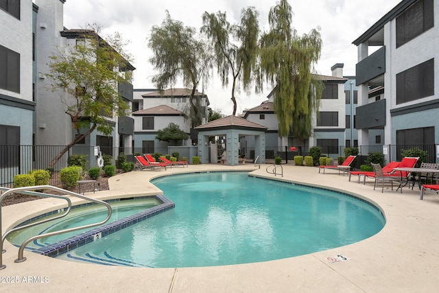 view of swimming pool with a patio area and a community hot tub