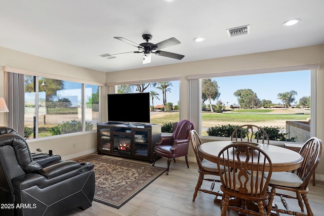 sunroom featuring a ceiling fan, visible vents, and a wealth of natural light