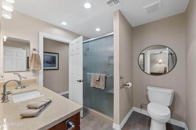 bathroom with a shower stall, wood finished floors, visible vents, and a sink