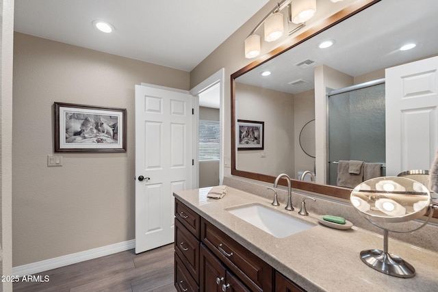 full bathroom featuring visible vents, baseboards, a stall shower, wood finished floors, and vanity