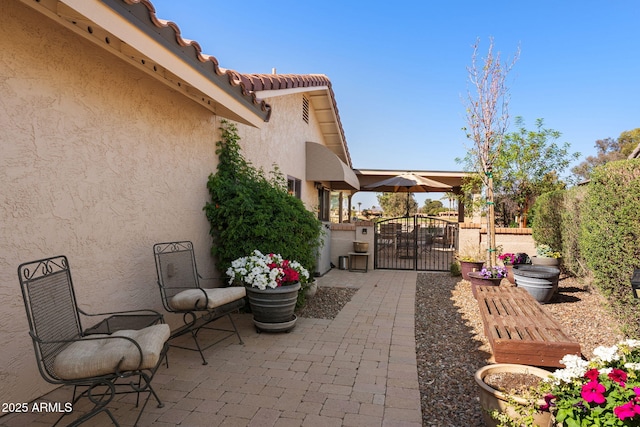 view of patio featuring fence and a gate