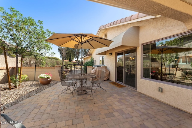 view of patio with outdoor dining area and fence