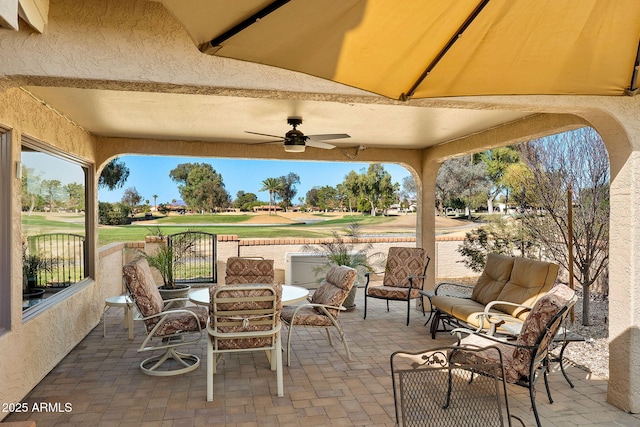 view of patio with an outdoor hangout area, view of golf course, and ceiling fan