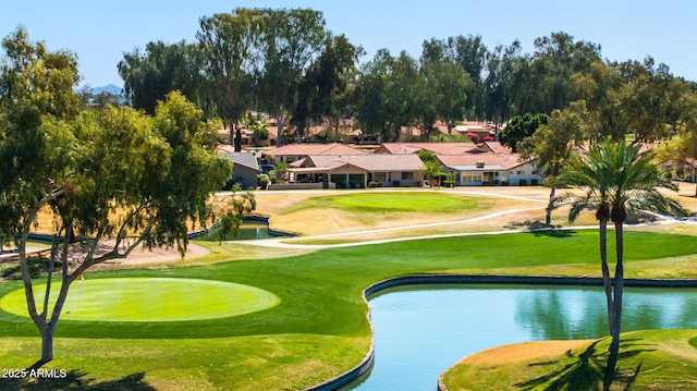 view of property's community with a water view, a lawn, and view of golf course