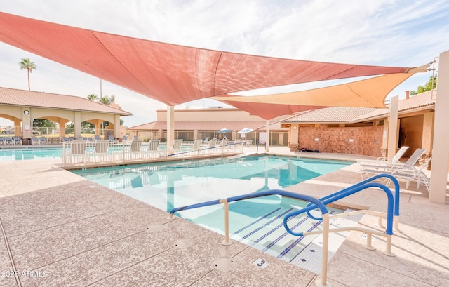 pool featuring fence and a patio area