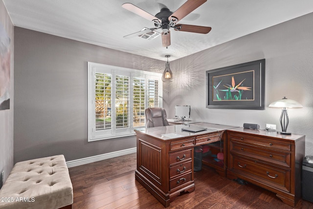 office with dark wood-type flooring, visible vents, baseboards, and a ceiling fan