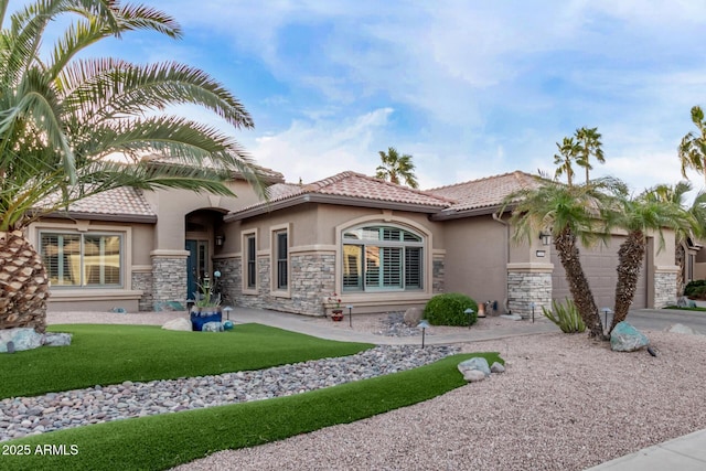 view of front facade featuring a tile roof, stucco siding, a garage, stone siding, and driveway