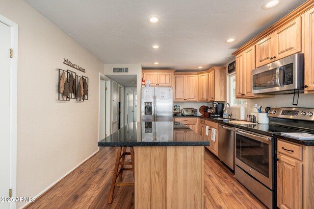 3971 N Apache Trl, Pine, AZ 85544 - kitchen with appliances with stainless steel finishes, light wood-type flooring, a kitchen breakfast bar, recessed lighting, and a center island