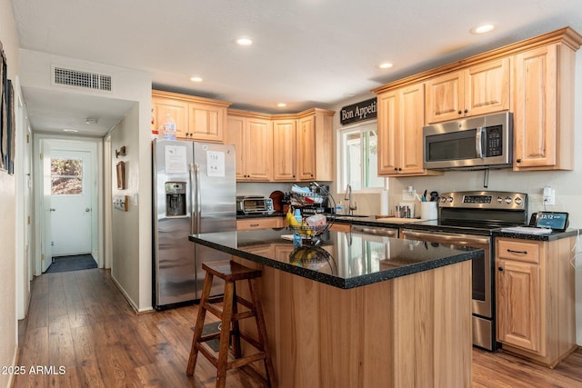 3971 N Apache Trl, Pine, AZ 85544 - kitchen featuring stainless steel appliances, dark wood-type flooring, light brown cabinetry, a sink, and a kitchen bar