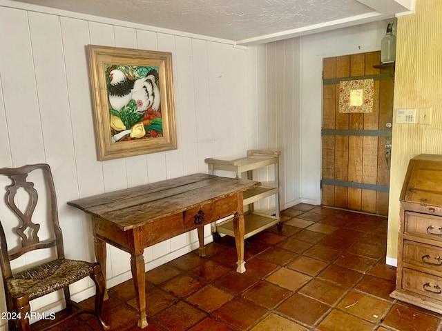 dining room with wooden walls and a textured ceiling