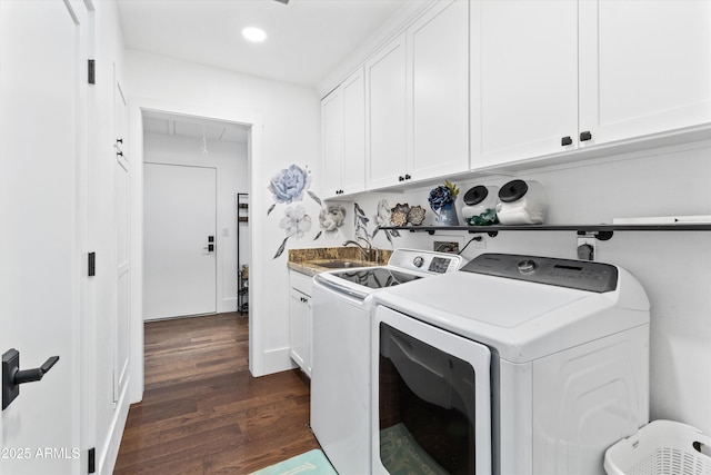 clothes washing area featuring sink, cabinets, dark wood-type flooring, and washer and clothes dryer