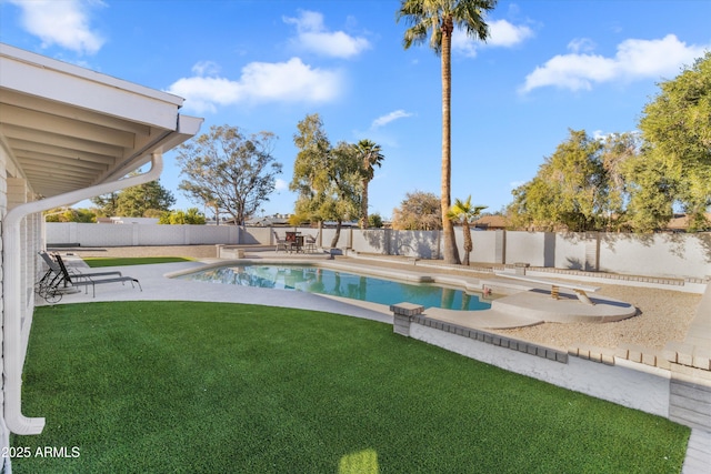 view of swimming pool with a diving board, a patio, and a yard