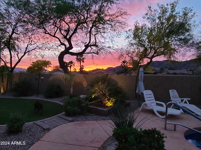 yard at dusk featuring a patio area