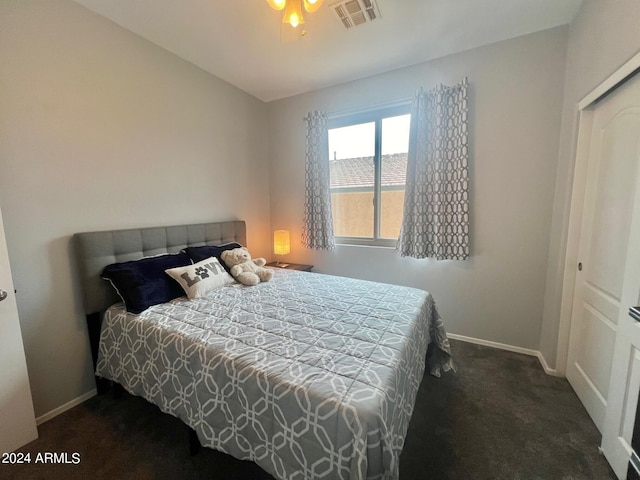 bedroom with dark carpet, a closet, and ceiling fan