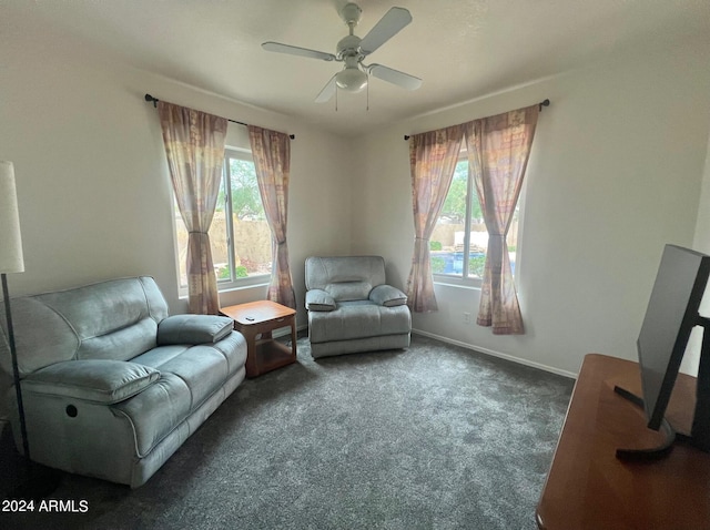 sitting room with dark carpet and ceiling fan