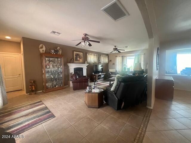 living room featuring tile patterned flooring, plenty of natural light, and ceiling fan