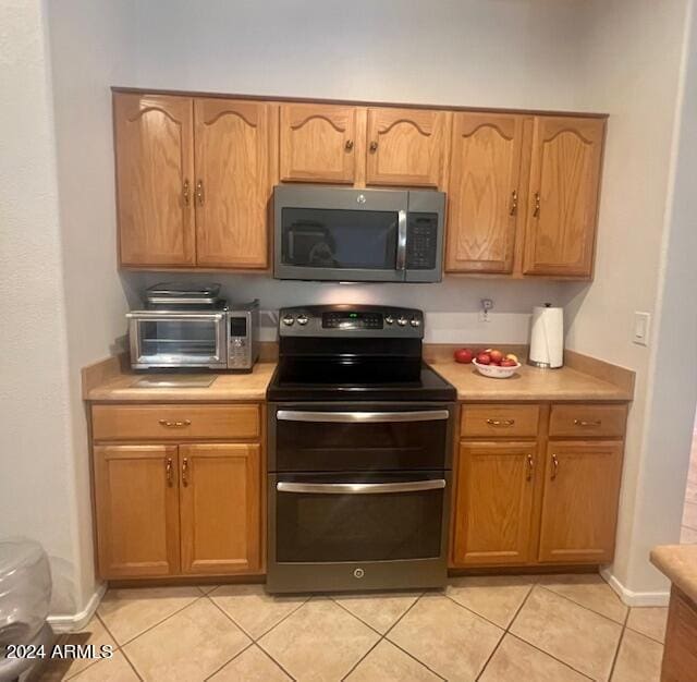 kitchen featuring stainless steel appliances and light tile patterned flooring