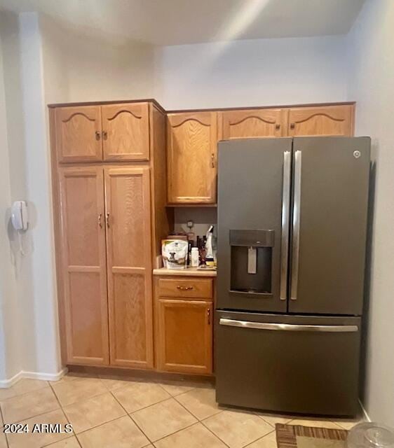 kitchen with light tile patterned floors and stainless steel fridge