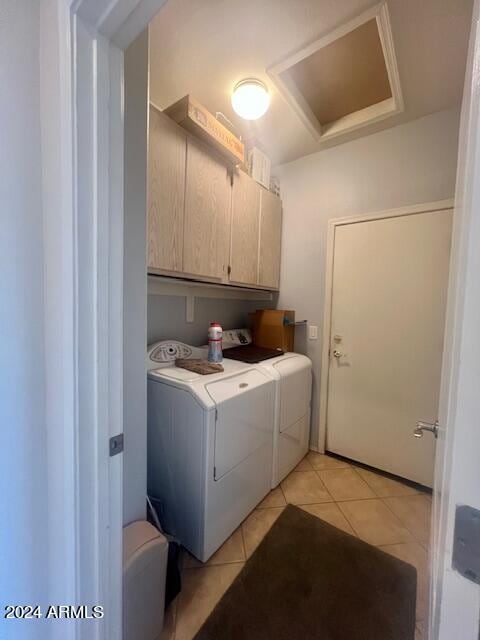 laundry room featuring light tile patterned floors, cabinets, and washer and dryer