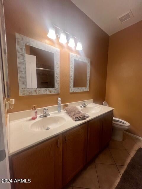 bathroom with tile patterned flooring, vanity, and toilet