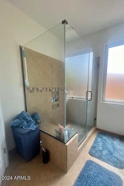 bathroom with a shower with shower door and tile patterned flooring