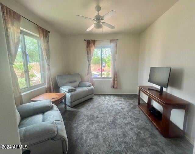 carpeted living room with ceiling fan