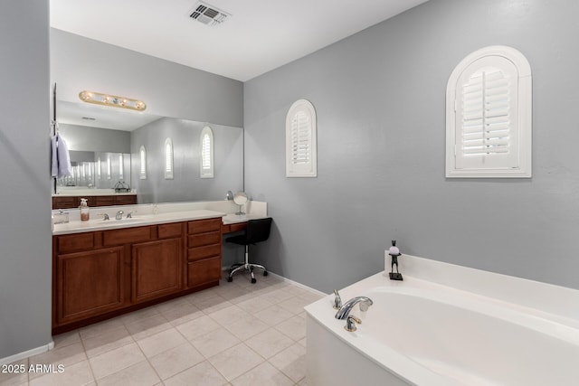 bathroom featuring tile patterned flooring, vanity, and a tub