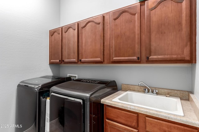 clothes washing area featuring cabinets, separate washer and dryer, and sink