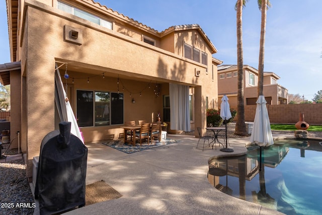 back of property with a balcony and a patio