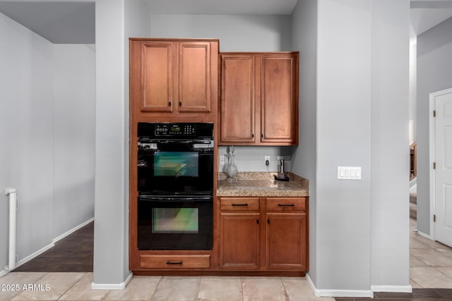 kitchen featuring black double oven and light tile patterned flooring