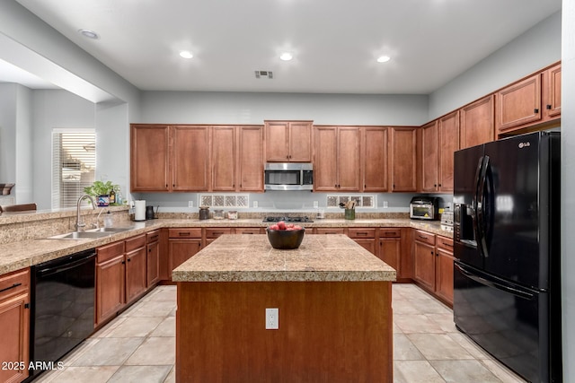 kitchen with sink, light tile patterned flooring, black appliances, and a kitchen island