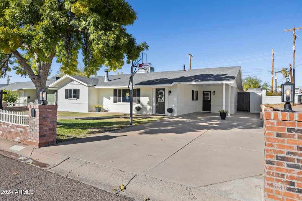 ranch-style home with a carport and a front yard