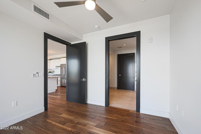 empty room with ceiling fan and dark hardwood / wood-style flooring