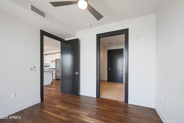 empty room featuring ceiling fan and dark wood-type flooring