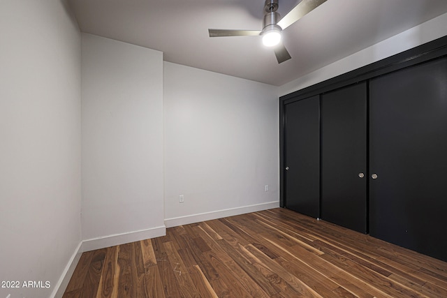 unfurnished bedroom with a closet, ceiling fan, and dark wood-type flooring