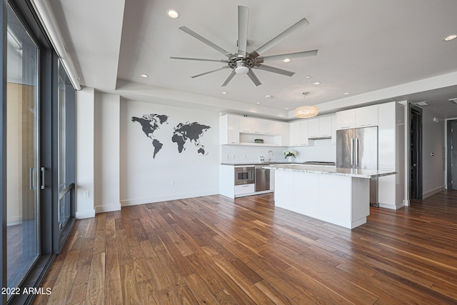 kitchen with a center island, stainless steel appliances, dark hardwood / wood-style floors, and white cabinetry