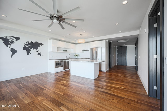 kitchen featuring stainless steel appliances, dark hardwood / wood-style floors, white cabinetry, and a kitchen island