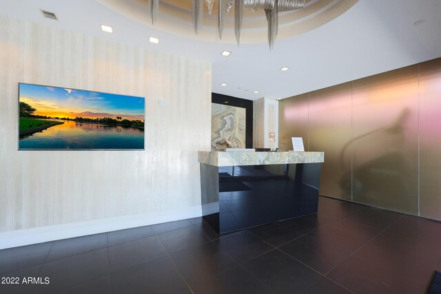 bar with dark stone counters and light hardwood / wood-style floors