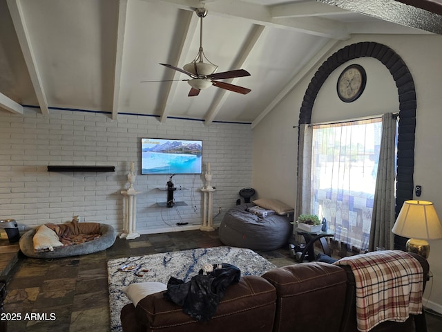 living room featuring lofted ceiling with beams, brick wall, and ceiling fan