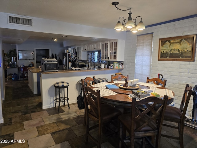 dining area featuring a notable chandelier and visible vents
