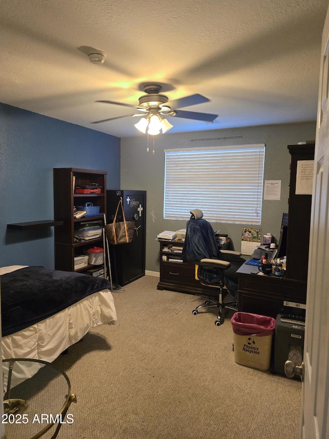 carpeted bedroom featuring ceiling fan and a textured ceiling
