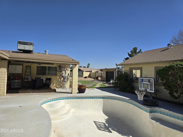 view of swimming pool with a patio, an empty pool, and central AC