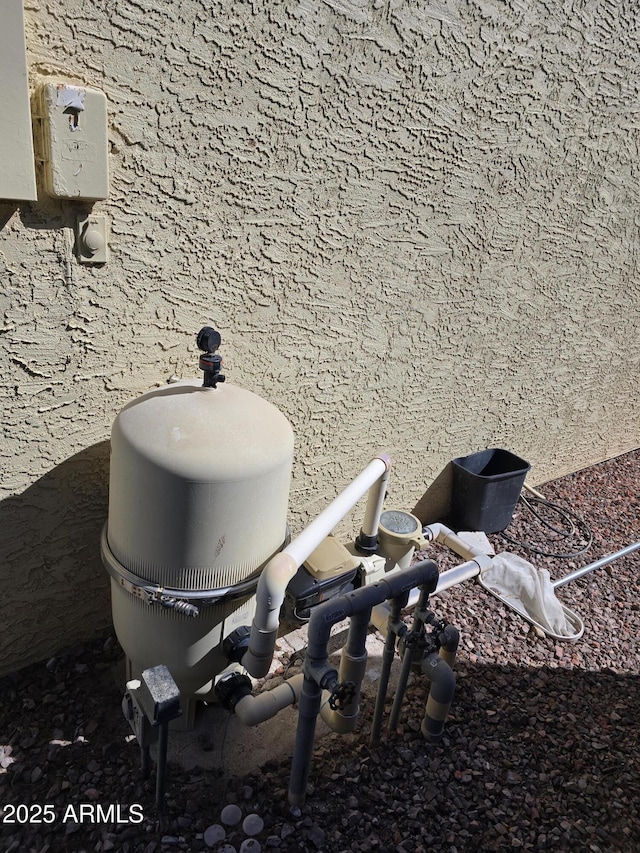 details featuring stucco siding and pump