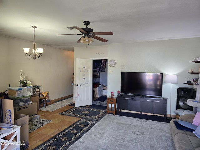 tiled living room featuring baseboards and ceiling fan with notable chandelier